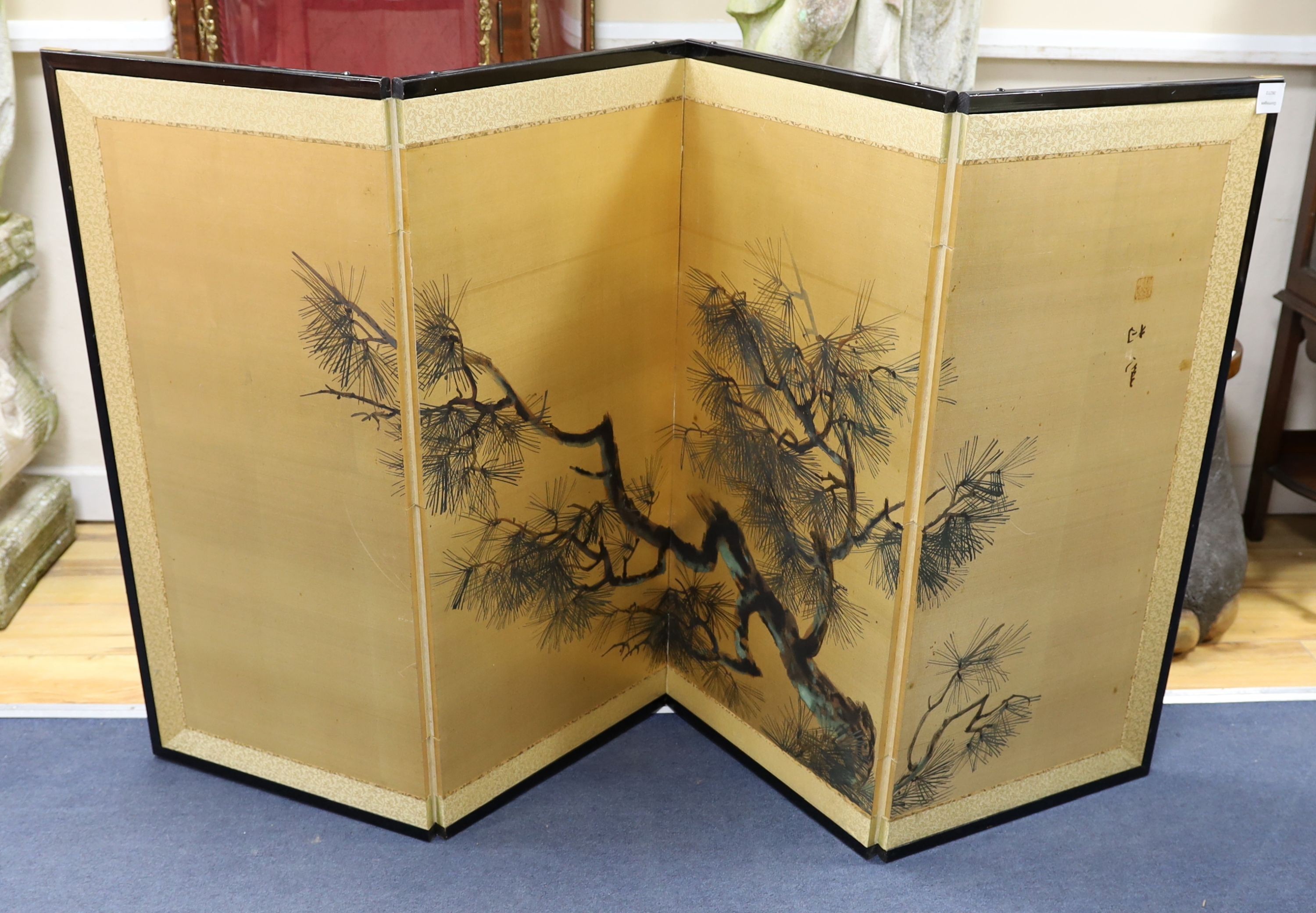 A Japanese gilt screen decorated with pine branches together with a Chinese rectangular wall mirror and a low table.
